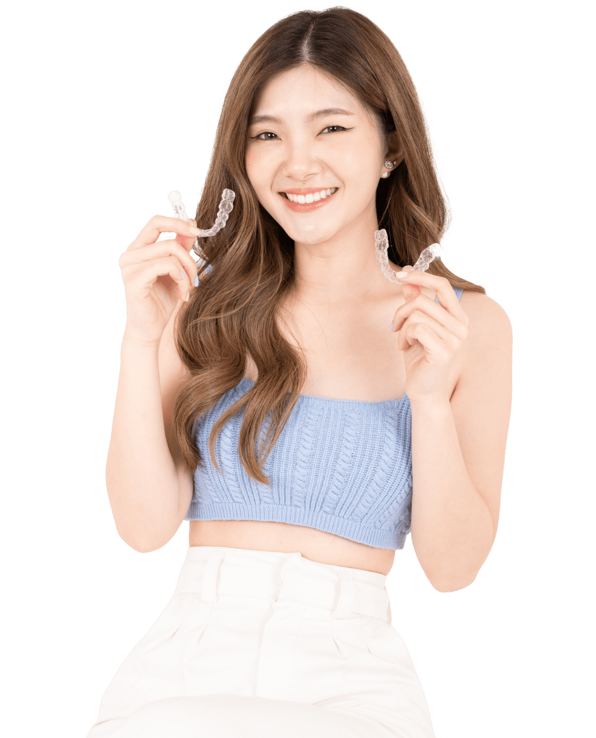 Smiling woman showing clear aligners in both hands, representing aligner treatment confidence