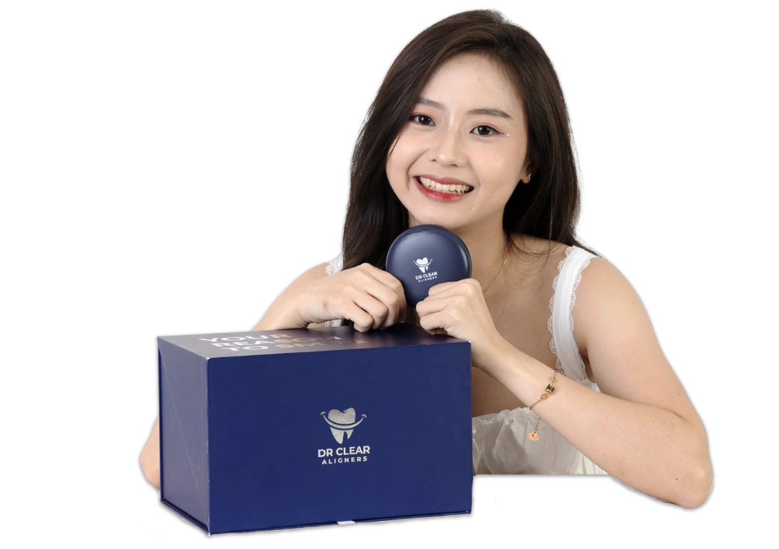 Smiling woman posing with Dr Clear Aligners box and aligner case.